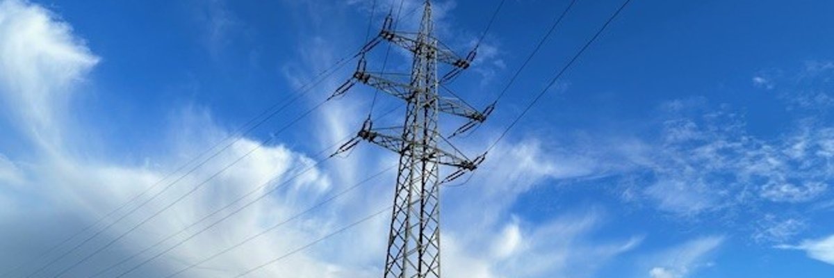 Ein Strommast mit Wolken im Hintergrund