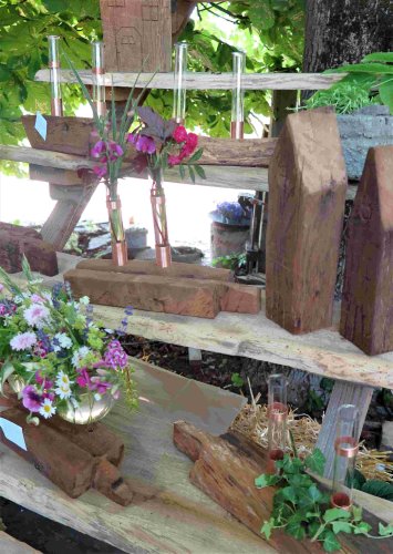 Gartencafé Sieburg: Blumengefäße aus Glas auf Eichenholz von Werner Sieburg und seinen Freunden. (Gemeinde Wachtberg/mm)
