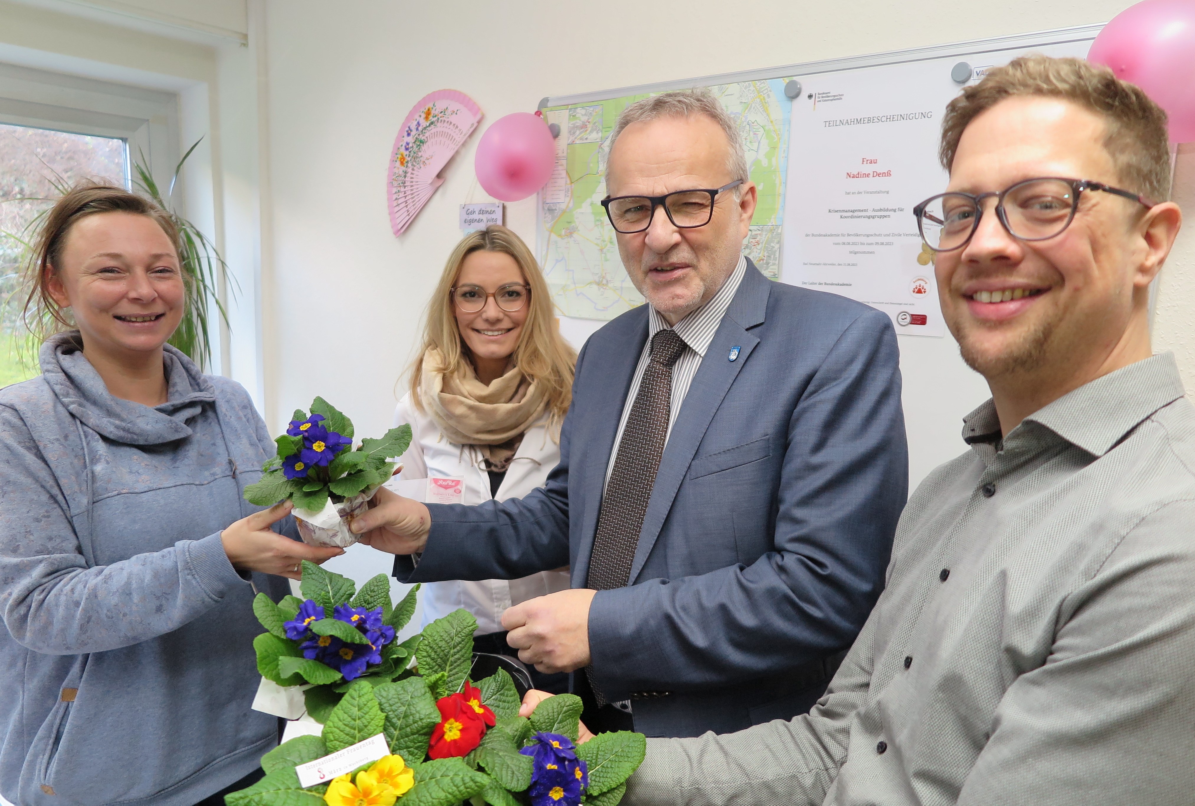 Bürgermeister Jörg Schmidt (2.v.r.), Beigeordneter Swen Christian (r.) und Gleichstellungsbeauftragte Tamara Schneider (2.v.l.) überreichen den Rathaus-Mitarbeiterinnen ein blumiges „Dankeschön“. 