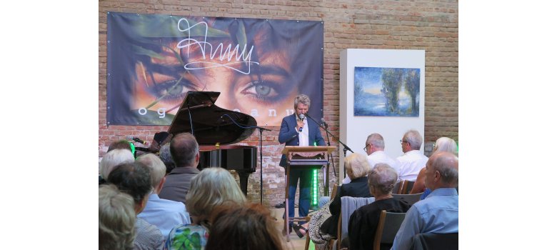 Michael Franke begrüßte die Gäste zum Auftaktkonzert der 17. Wachtberger Kulturwochen in seinem Atelier. Michael Franke am Rednerpult in seinem Atelier.