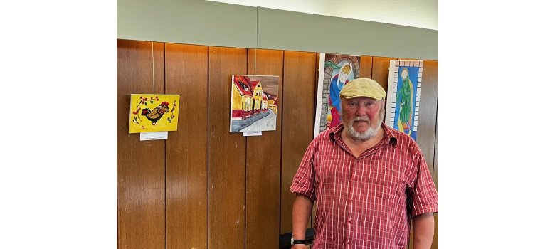 Dr. Wolfgang Osterhage vor drei seiner Bilder - u.a. links das Teekannen-Motiv.